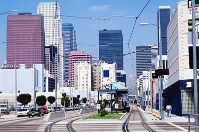 photo of a big-city downtown, with a light-rail station and tracks.