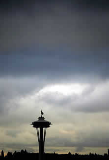 photo of the Seattle Space Needle building, with a stormy sky behind