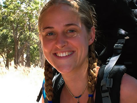 photo of a smiling young woman wearing a backpack